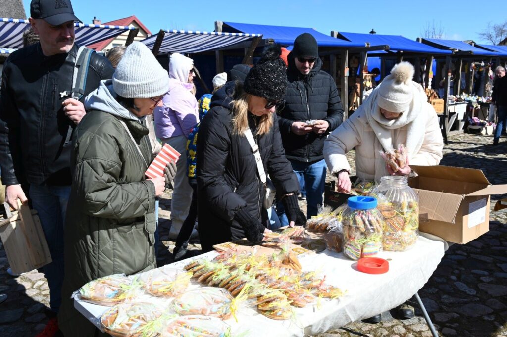 Stoisko ze słodkimi wypiekami i przekąskami, przy którym odwiedzający wybierają produkty podczas jarmarku (kliknięcie powiększy zdjęcie).