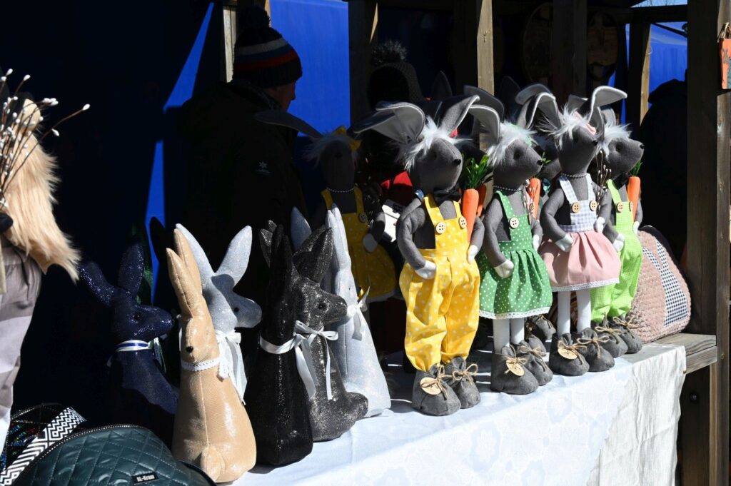 Stoisko z ręcznie wykonanymi dekoracjami wielkanocnymi, w tym figurkami zajęcy ustawionymi w rzędzie (kliknięcie powiększy zdjęcie).