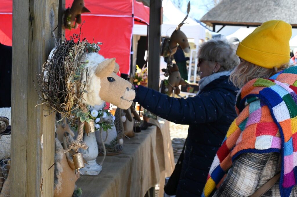 Kobiety oglądające wielkanocne dekoracje i rękodzieło na stoisku podczas jarmarku (kliknięcie powiększy zdjęcie
