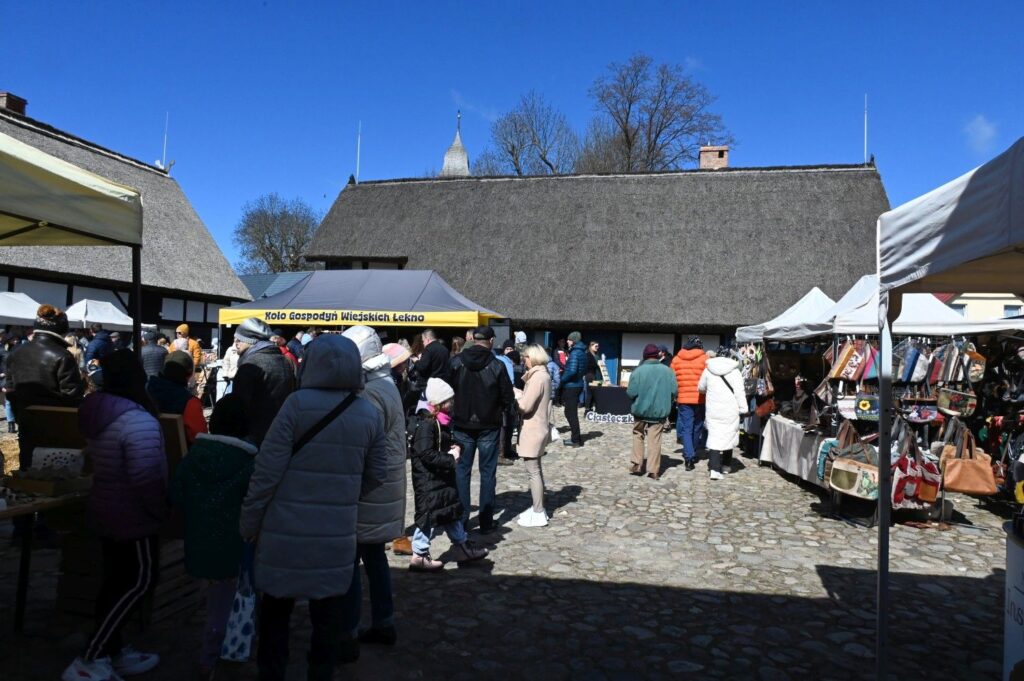Tłum odwiedzających spacerujących między stoiskami jarmarku wielkanocnego na dziedzińcu Zagrody (kliknięcie powiększy zdjęcie).