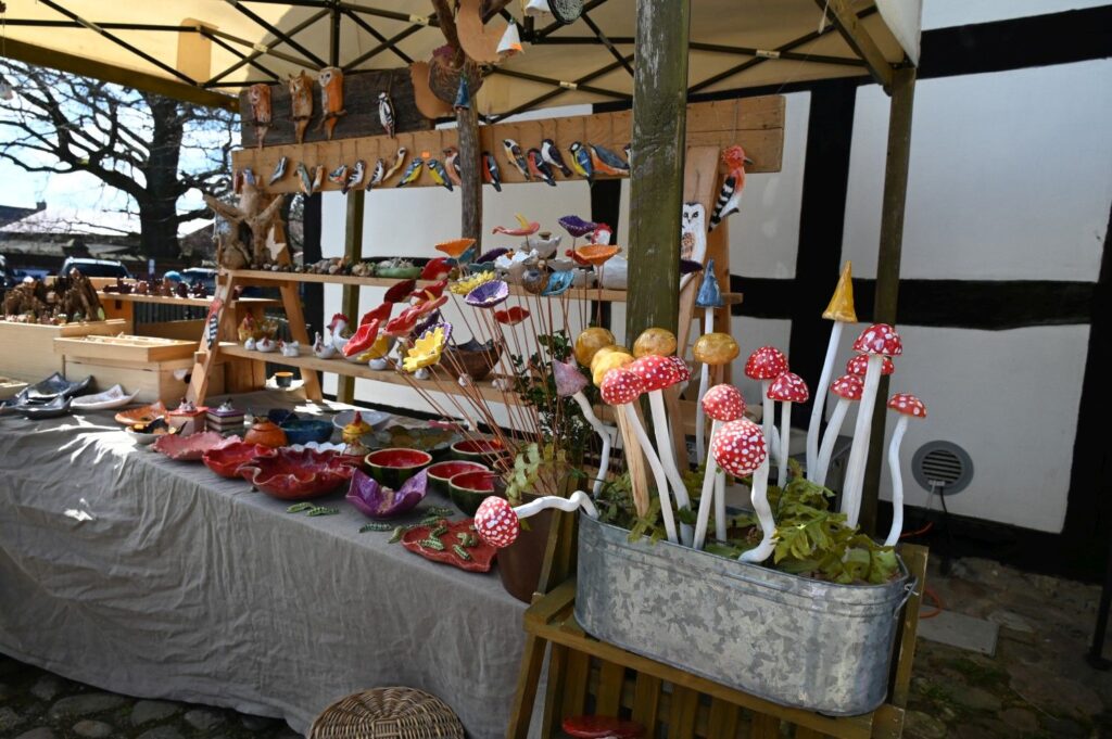 Stoisko z kolorowym rękodziełem i dekoracjami wielkanocnymi ustawione przy jednej z chałup skansenu (kliknięcie powiększy zdjęcie).
