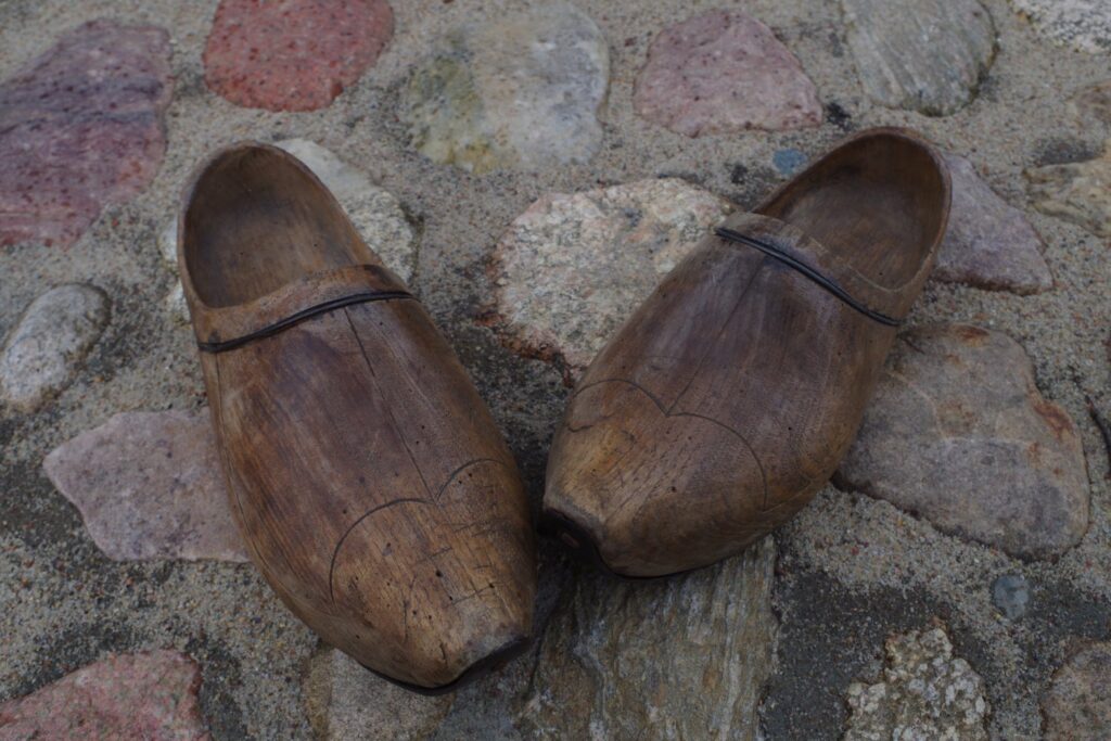 Para drewnianych chodaków leżących na kamiennym podłożu jako element ekspozycji etnograficznej (kliknięcie powiększy zdjęcie).