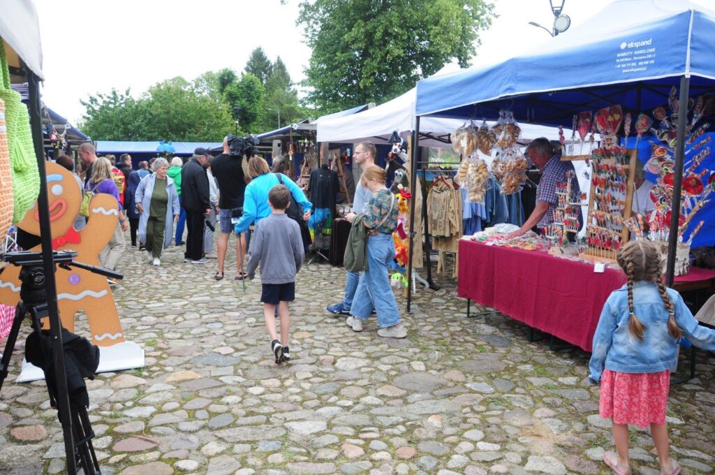 Stoiska na Jarmarku Jamneńskim, gdzie odwiedzający oglądają rękodzieło i regionalne wyroby (kliknięcie powiększy zdjęcie).