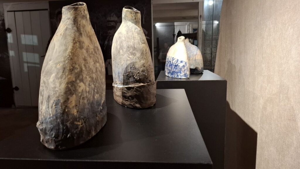 Trzy ceramiczne obiekty artystyczne ustawione na czarnych postumentach w przestrzeni wystawowej (kliknięcie powiększy zdjęcie)