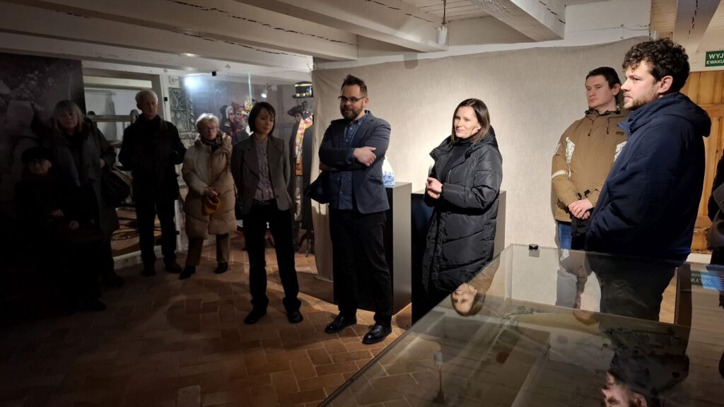 Uczestnicy wernisażu zgromadzeni w sali wystawowej, stojący przy gablotach i ekspozycjach (kliknięcie powiększy zdjęcie)