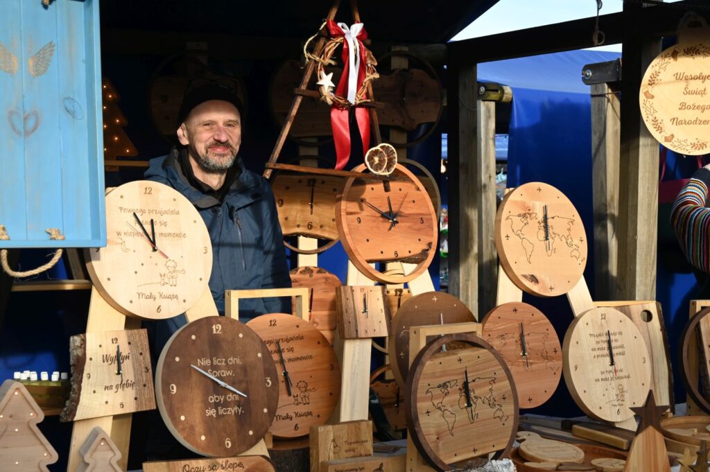 Stoisko z ręcznie wykonanymi drewnianymi zegarami i dekoracjami na jarmarku jamneńskim (kliknięcie powiększy zdjęcie).