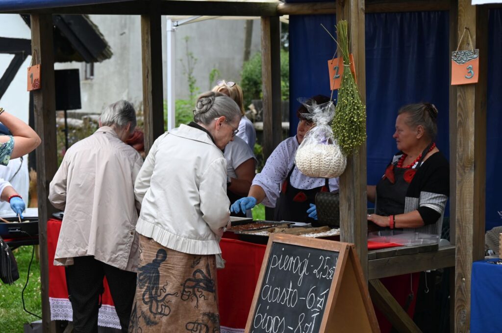 Stoisko z jedzeniem, przy którym odwiedzający zamawiają potrawy u sprzedawczyni stojącej za ladą z tablicą z menu (kliknięcie powiększy zdjęcie).