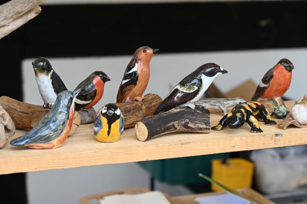 Małe ceramiczne figurki ptaków ustawione na drewnianej półce (kliknięcie powiększy zdjęcie).