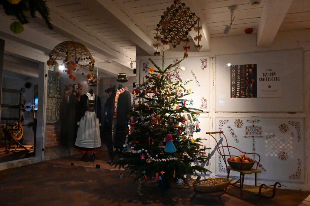 Świątecznie udekorowane wnętrze z choinką, tradycyjnymi strojami i ozdobami ludowymi (kliknięcie powiększy zdjęcie).
