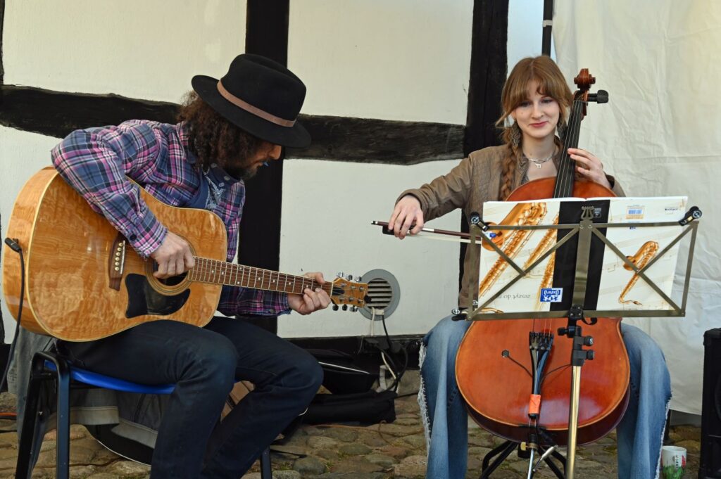 Muzycy grają na gitarze i wiolonczeli podczas występu na dziedzińcu muzeum (kliknięcie powiększy zdjęcie).