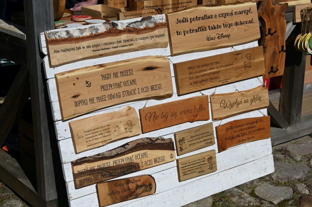 Drewniane tabliczki z grawerowanymi napisami i sentencjami wystawione na stoisku (kliknięcie powiększy zdjęcie).
