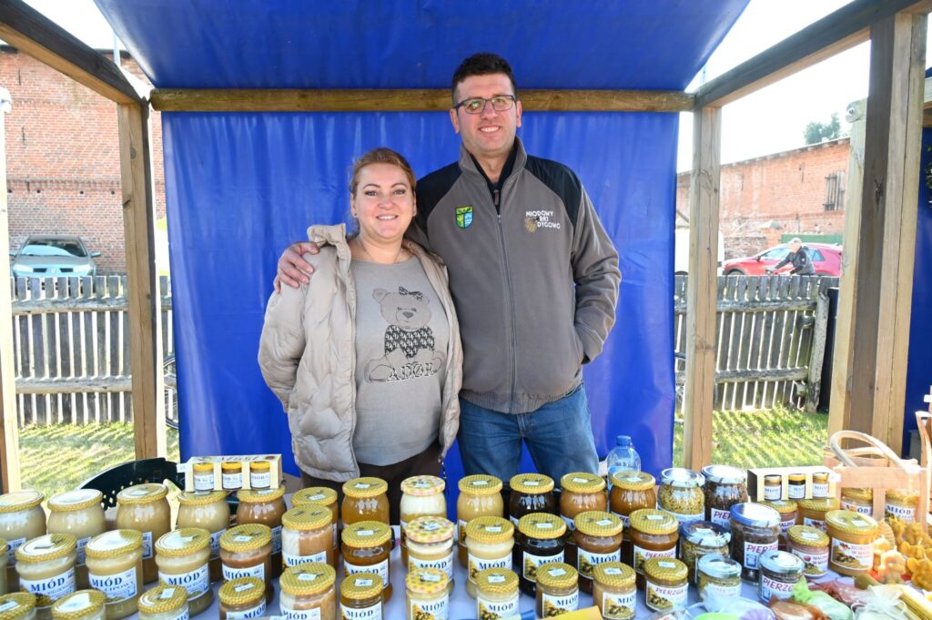 Wystawcy prezentują przetwory w słoikach na stoisku podczas jarmarku (kliknięcie powiększy zdjęcie).