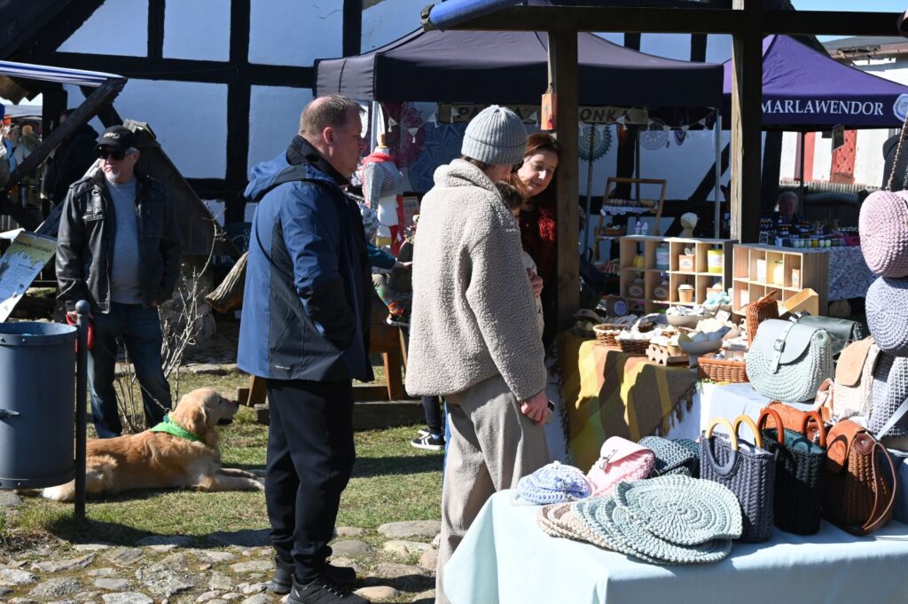 Stoisko z wyrobami rękodzielniczymi, gdzie odwiedzający przyglądają się torbom i dodatkom (kliknięcie powiększy zdjęcie).