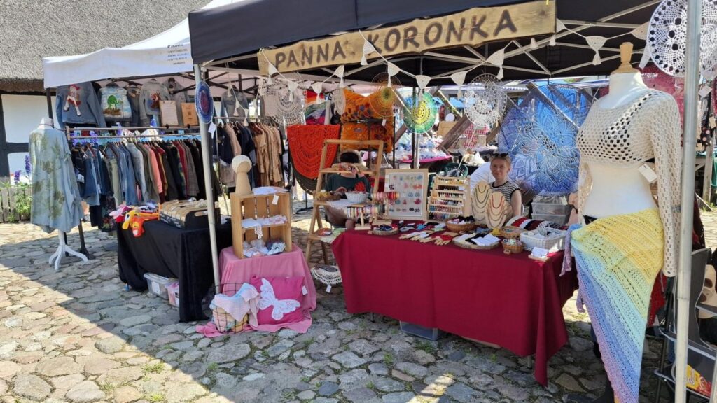Stoisko wystawcy prezentującego rękodzieło, odzież i ozdoby. Na pierwszym planie widoczne są wyroby jubilerskie i dekoracyjne. (kliknięcie powiększy zdjęcie).