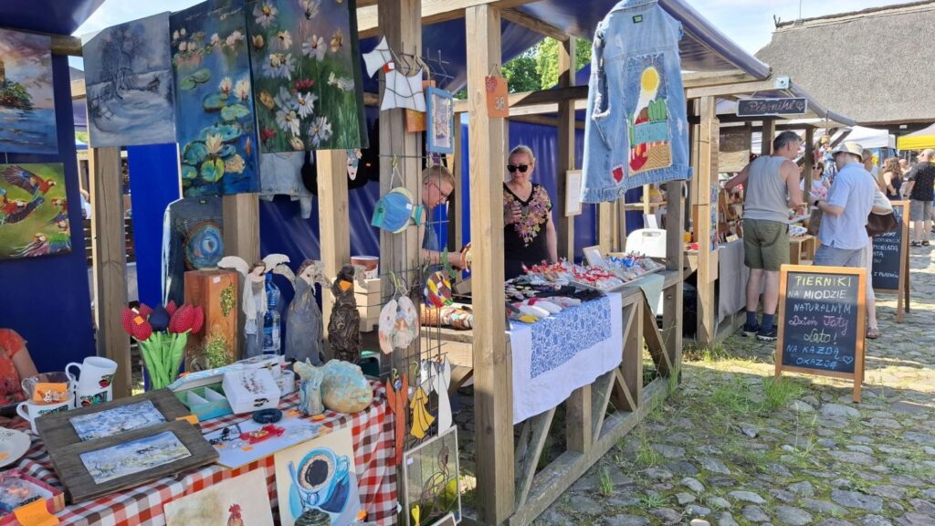 Stoisko z obrazami, dekoracjami i rękodziełem artystycznym prezentowanym podczas jarmarku. (kliknięcie powiększy zdjęcie).